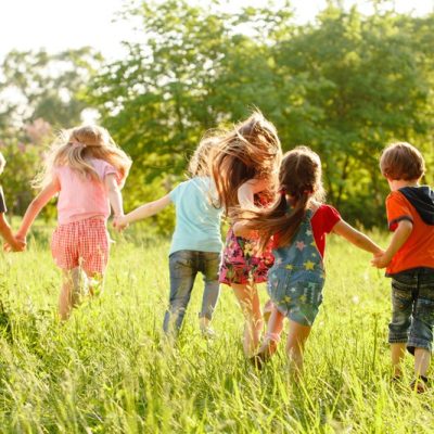 Spelende kinderen hand in hand in een grasveld